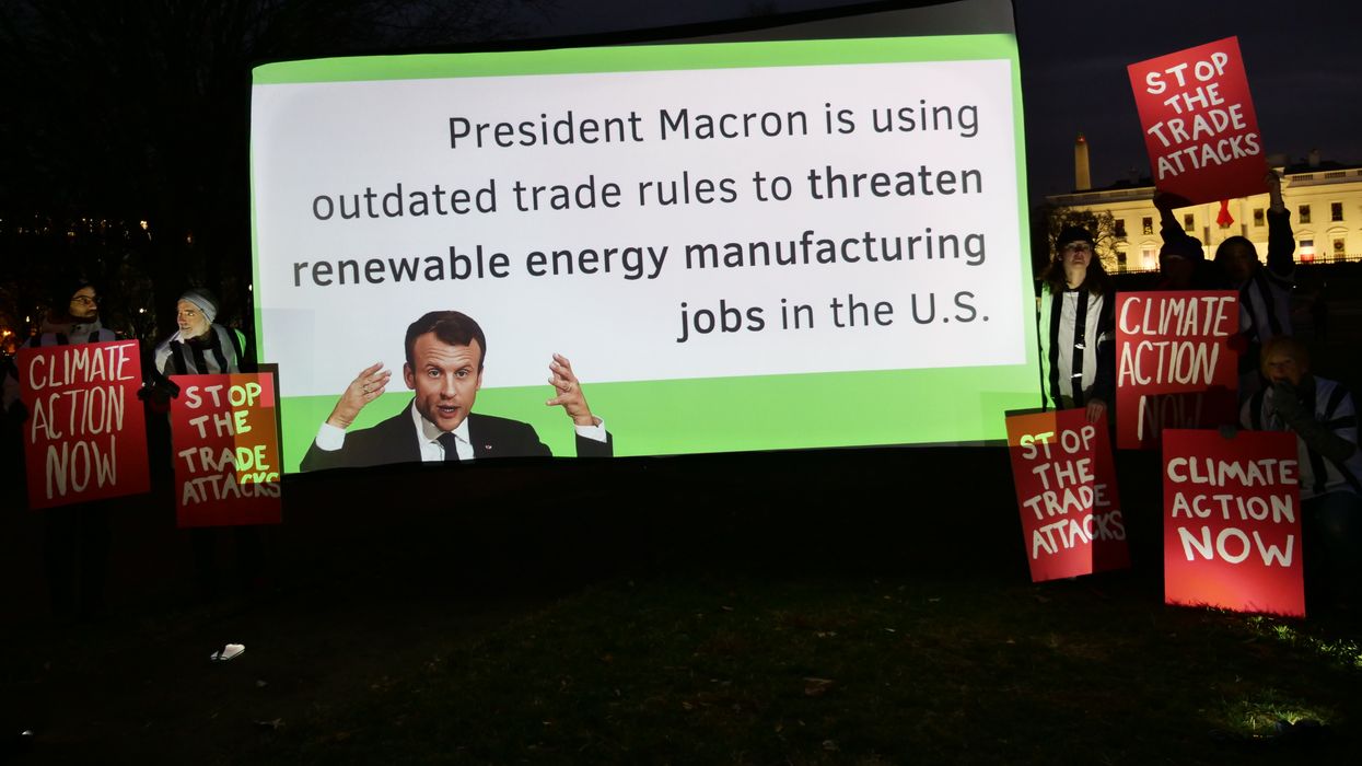 During a rally outside the White House on December 1, 2022, demonstrators urge French President Emmanuel Macron to stop using trade rules to block climate action.