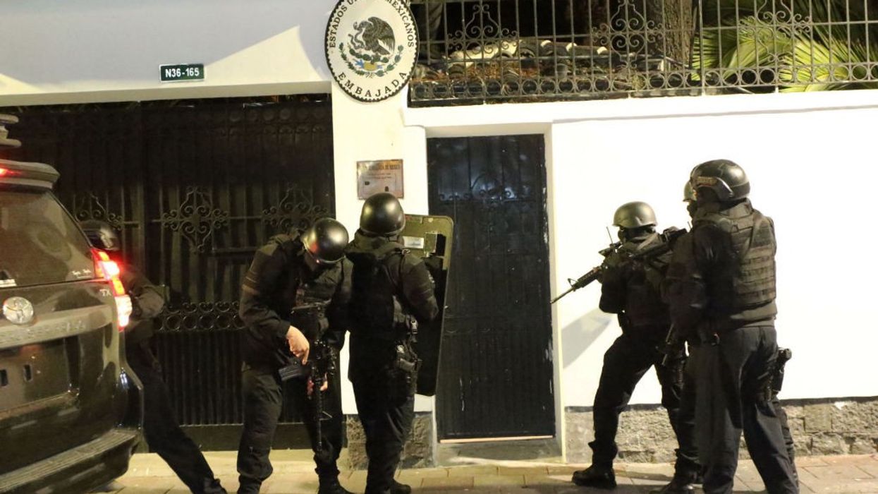 Ecuadorian police special forces in body armor prepare to break into the Mexican Embassy in Quito.