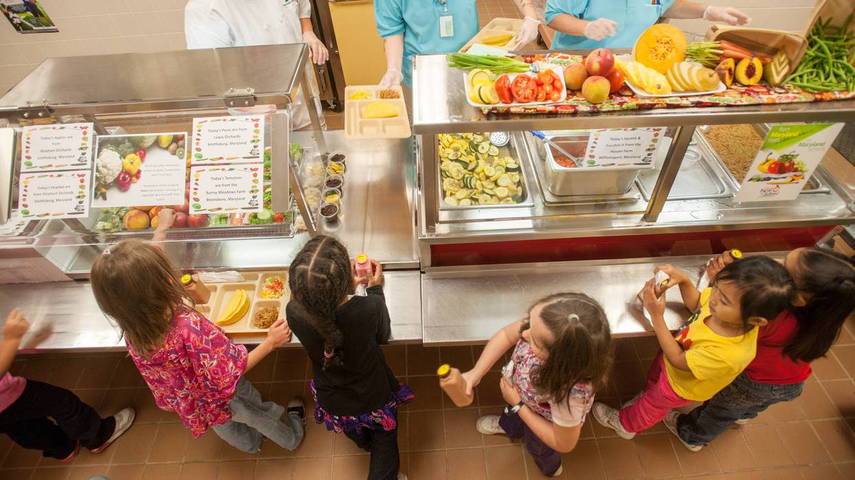 Elementary school children line up in a cafeteria