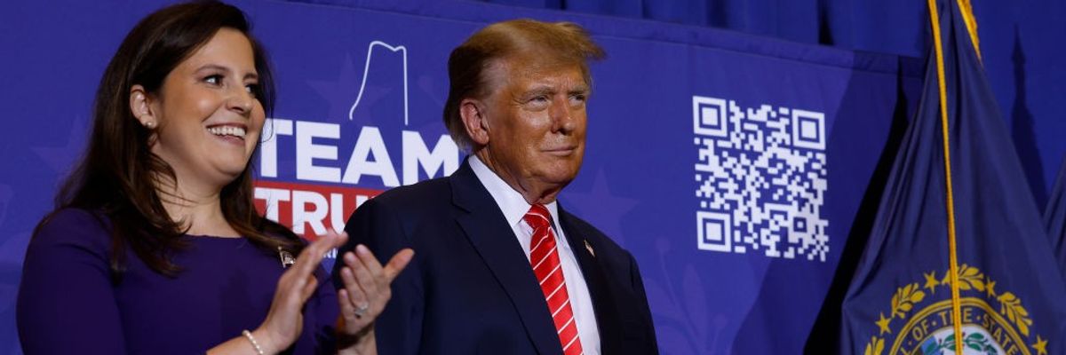 Elise Stefanik stands next to Donald Trump and applauds