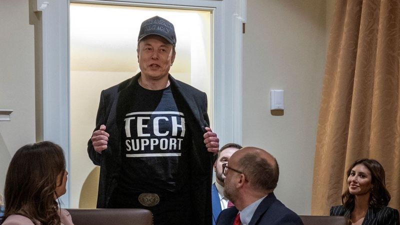 Elon Musk in Tech Support shirt.
