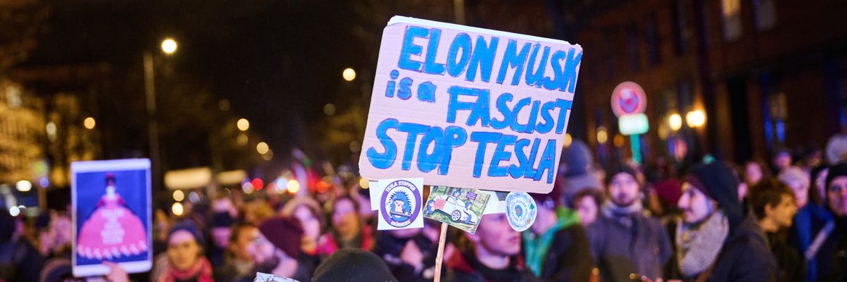 "Elon Musk is a Fascist—Stop Tesla" is written on a poster at a protest