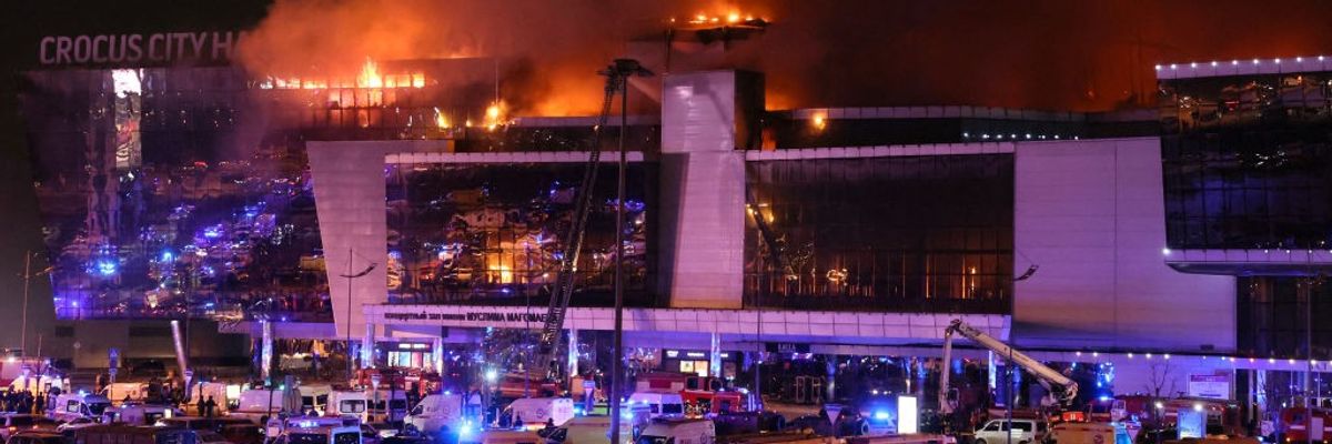 Emergency services vehicles are seen outside the burning concert hall 