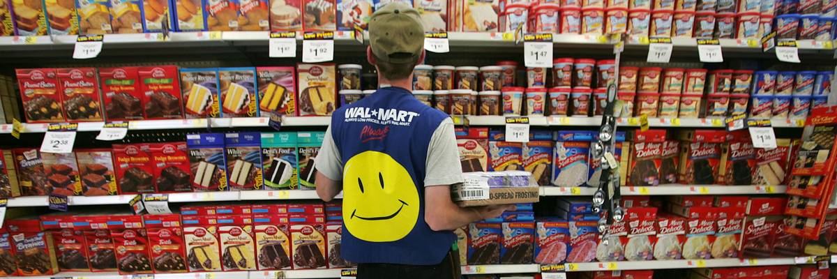 Employee in Walmart vest stocking shelves.