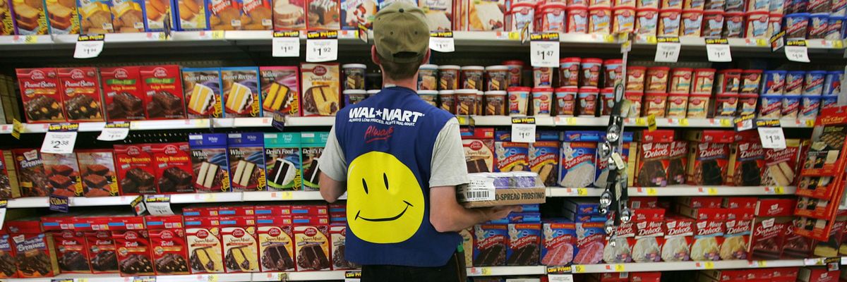 Employee in Walmart vest stocking shelves.