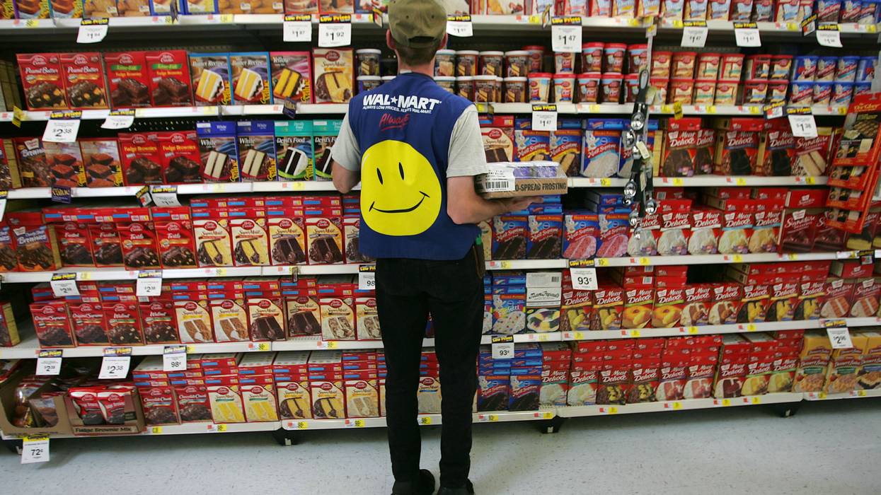 Employee in Walmart vest stocking shelves.