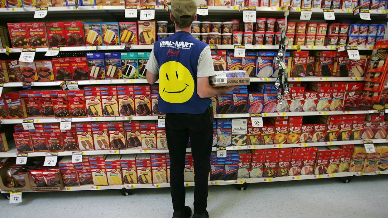 Employee in Walmart vest stocking shelves.