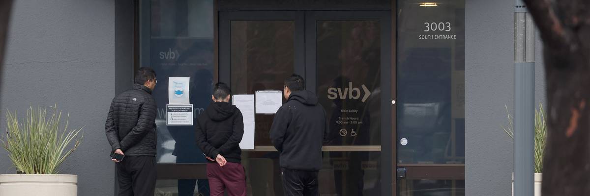 Employees stand outside shuttered SVB.