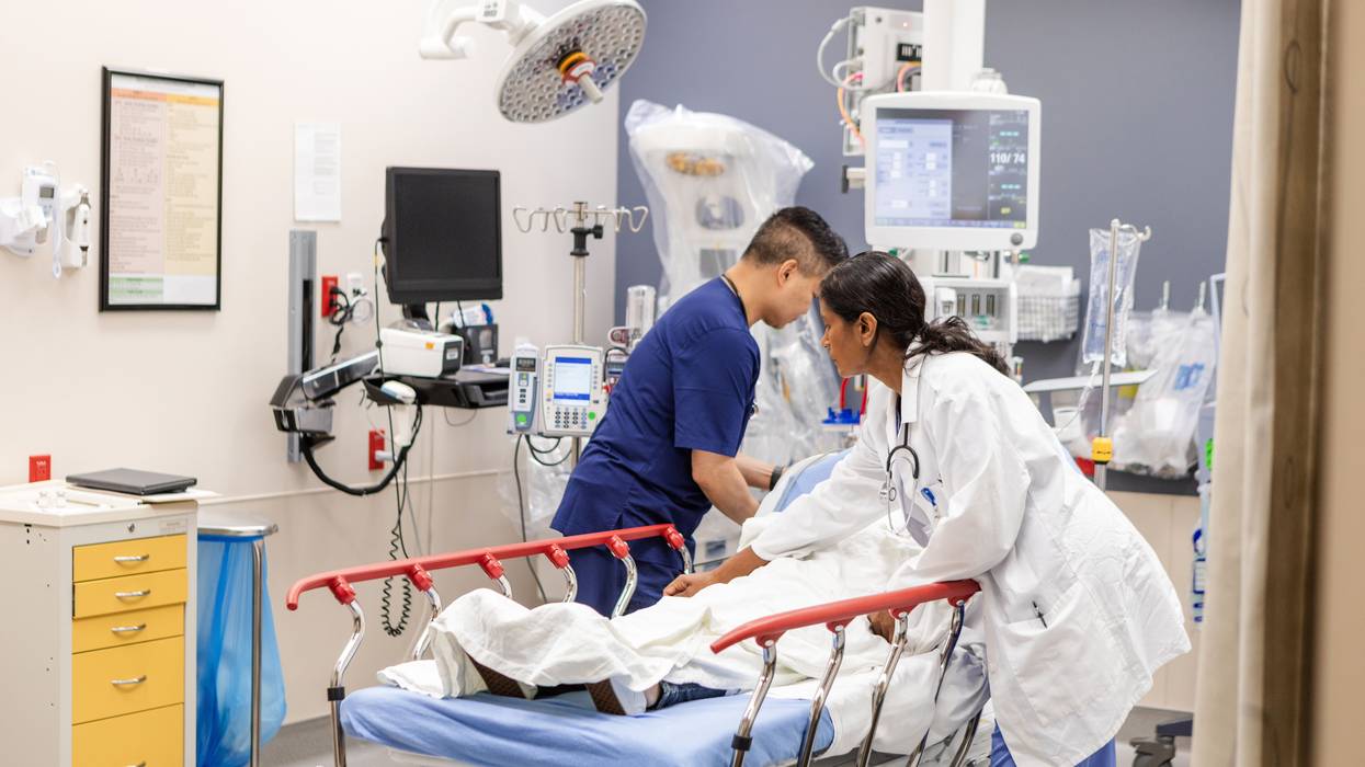 ER doctor and nurse prepare unconscious woman for examination