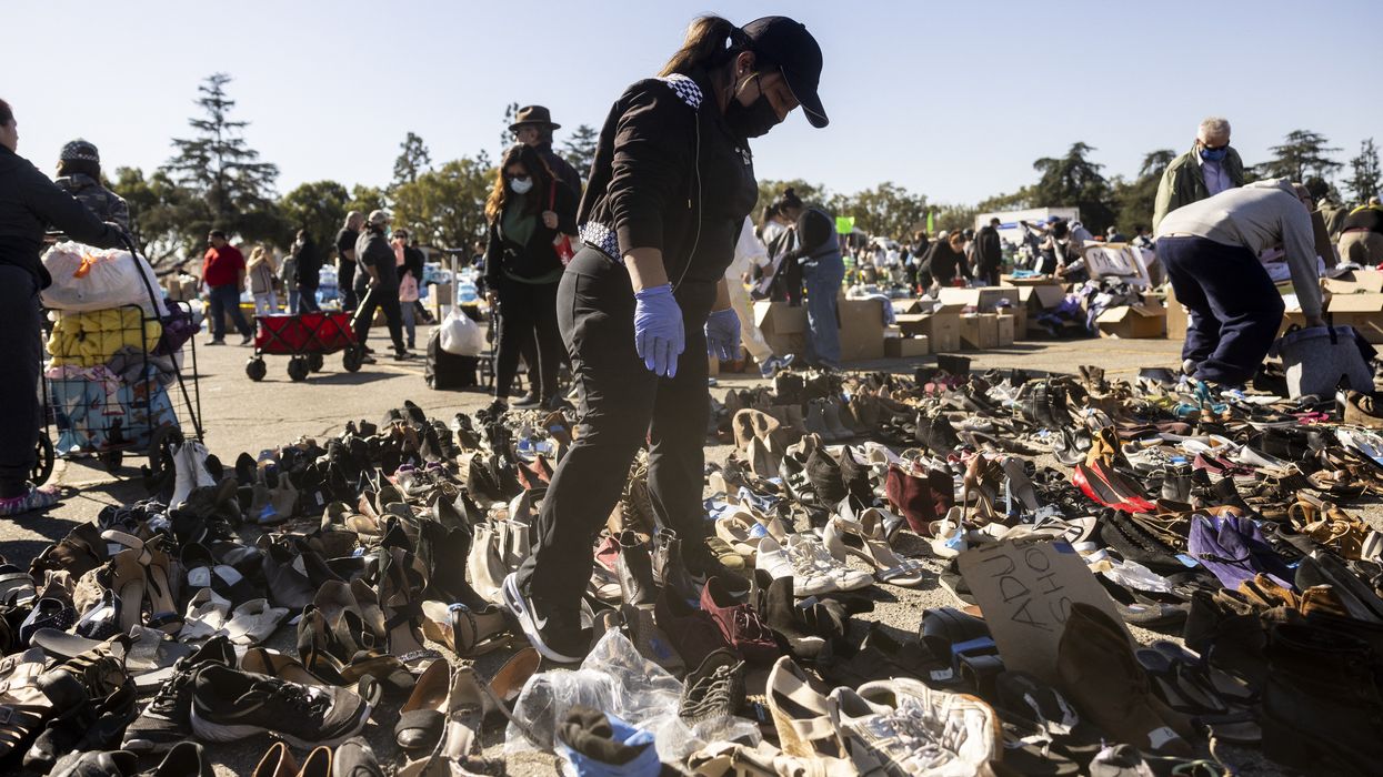 Evacuees from the Eaton Fire dwell among heaps of clothes displayed on the ground at a donation center in Santa Anita Park, Arcadia, California.