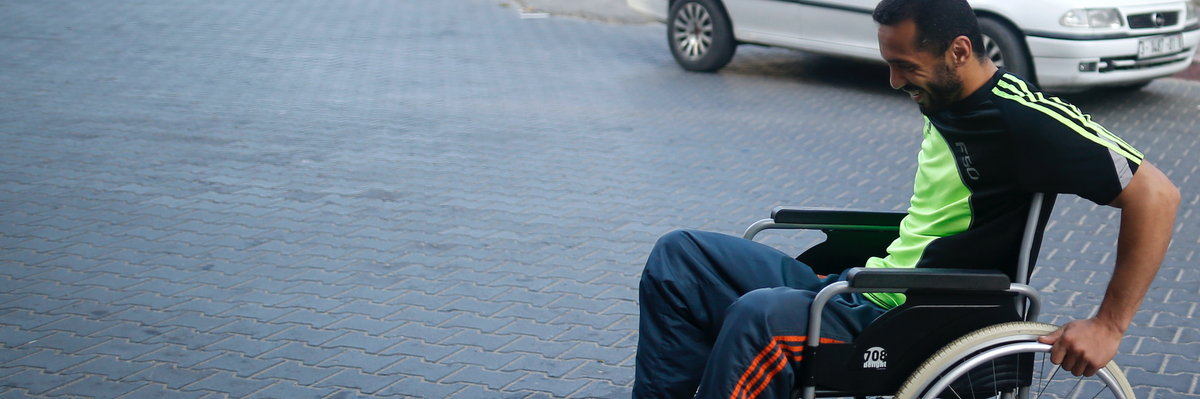 Fadi Deeb smiles in a wheelchair