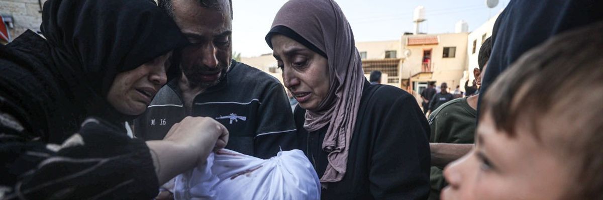 Family hold baby who was killed in Gaza.