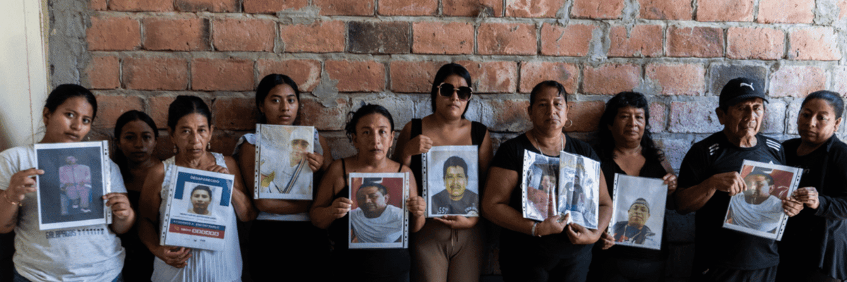 Family members hold photos of their loved ones, who have been missing at sea since January 20, 2026, when their fishing boat "went up in smoke" in international waters.