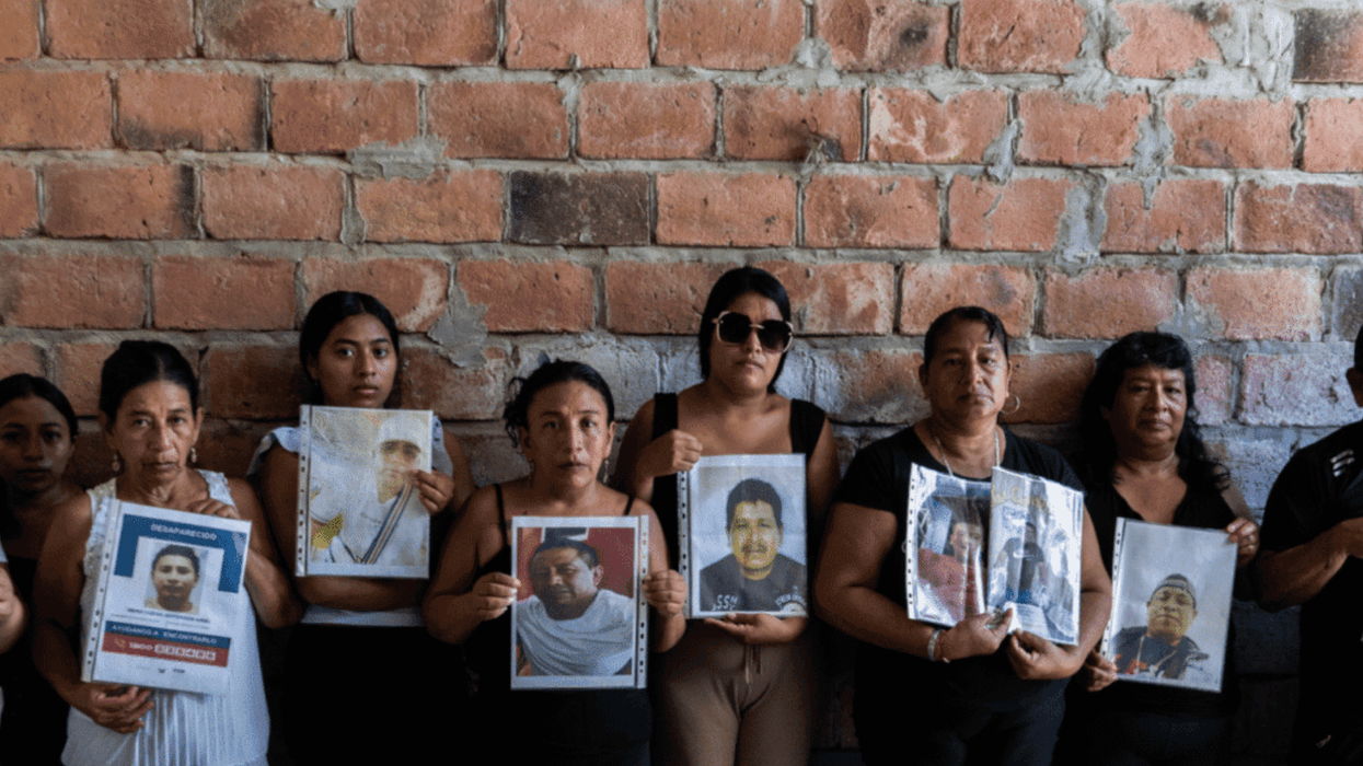 Family members hold photos of their loved ones, who have been missing at sea since January 20, 2026, when their fishing boat "went up in smoke" in international waters.