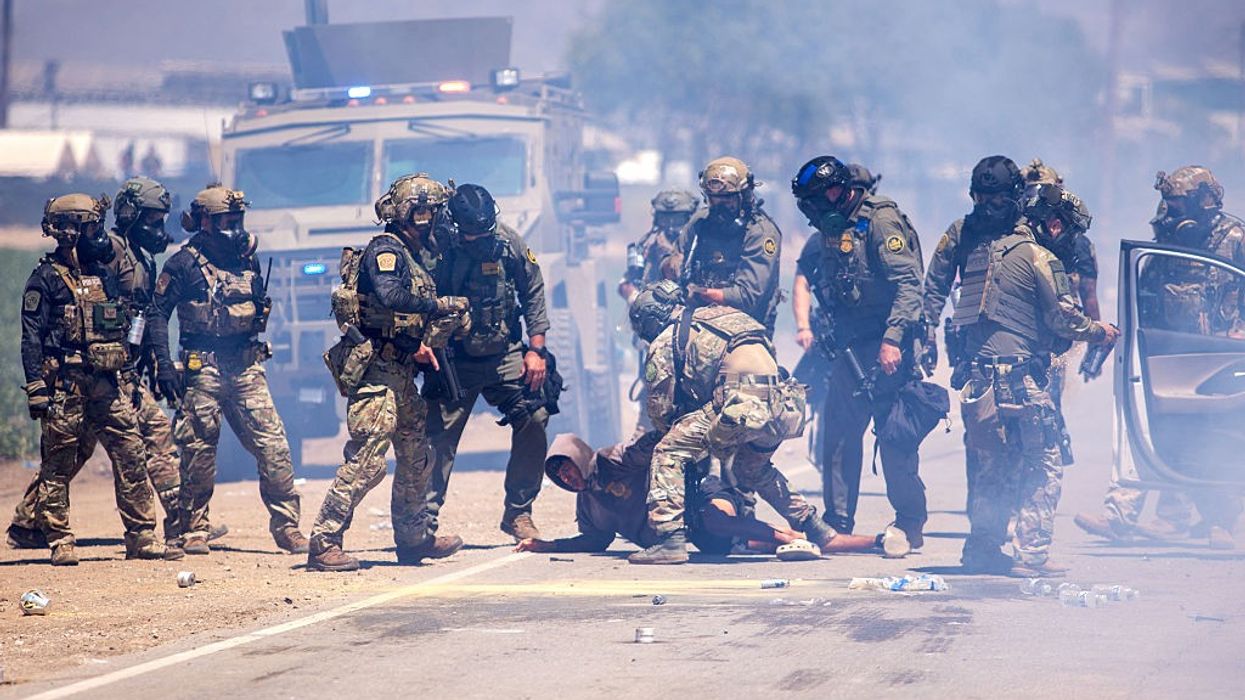 Federal agents arrest a person during a raid on a California farm