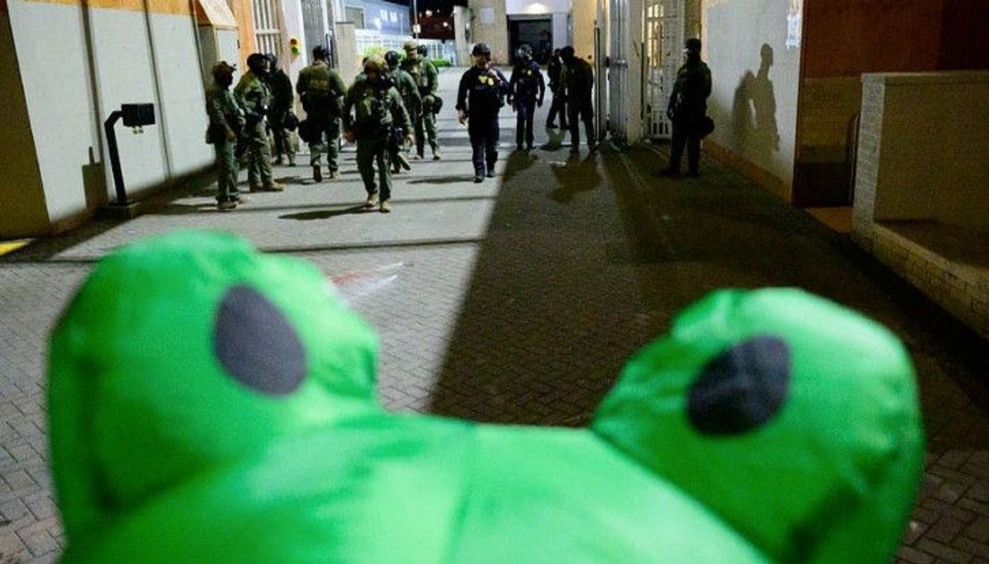 Federal agents face off against an inflatable frog in Portland.