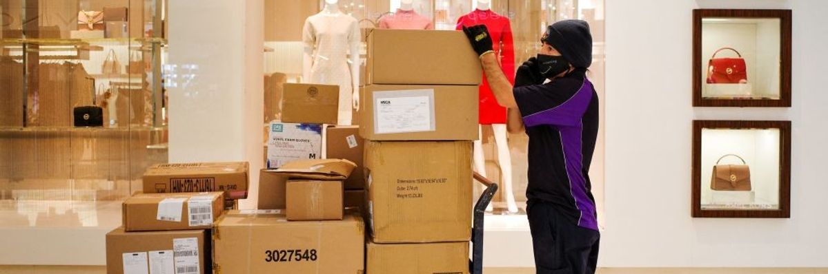 FedEx worker with stack of boxes inside shopping mall