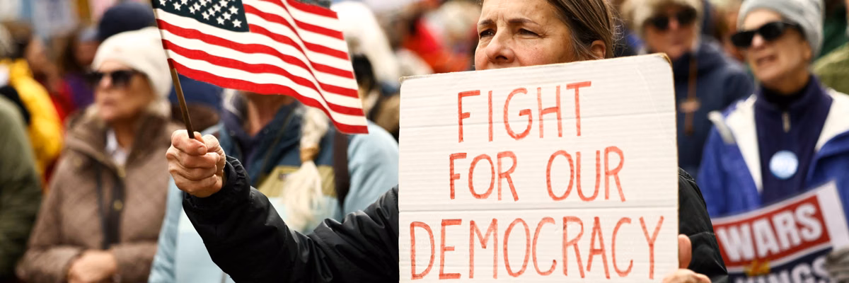 "Fight for Our Democracy" sign reads at No Kings protest in 2026