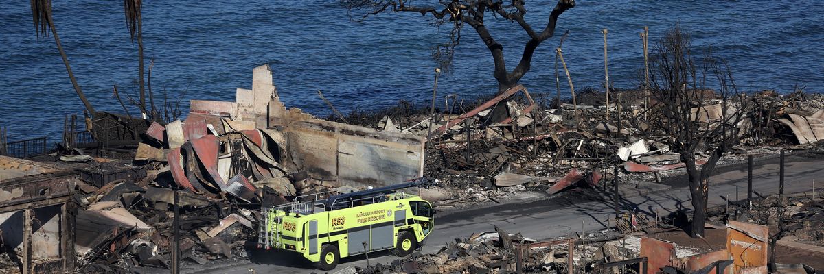 fire truck drives through a destroyed Lahaina neighborhood