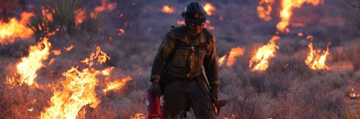 Firefighter among burning grass in Mojave National Preserve