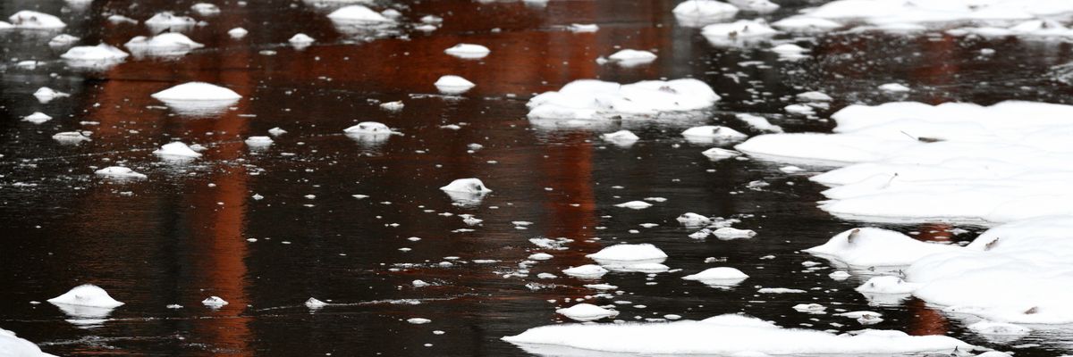 Firefighter foam is seen on the surface of water in Bensalem Township, Pennsylvania.