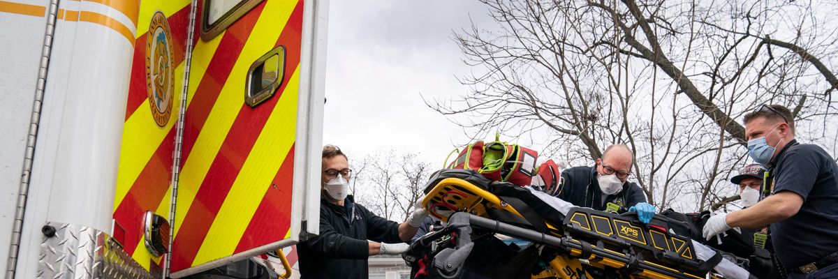 Firefighters and paramedics with Anne Arundel County Fire Department load a pediatric Covid-19 patient who is in cardiac arrest into an ambulance after responding to a 911 emergency call on January 17, 2022, in Glen Burnie, Maryland.