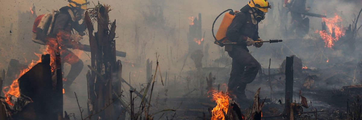 Firefighters and volunteers combat a fire on the Amazonia rainforest i