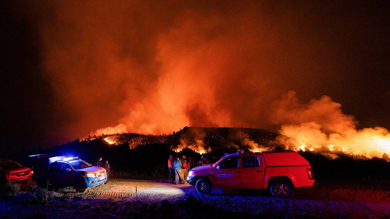 Firefighters fight a fire in the mountains of Argentina at night.