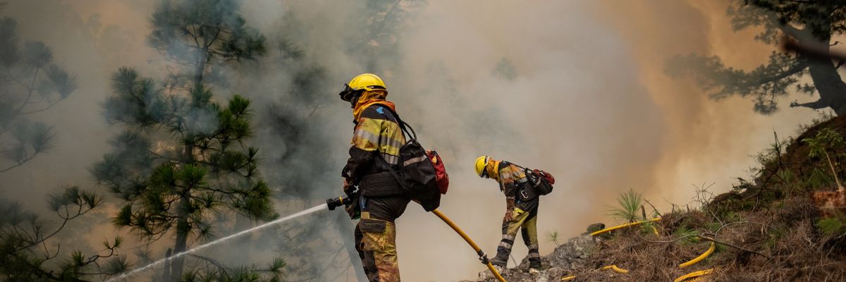Firefighters work to put out a blaze in La Palma