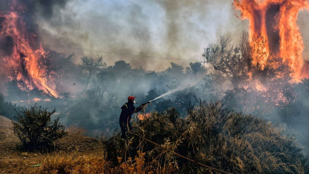 Fireman dousing flames in Greece