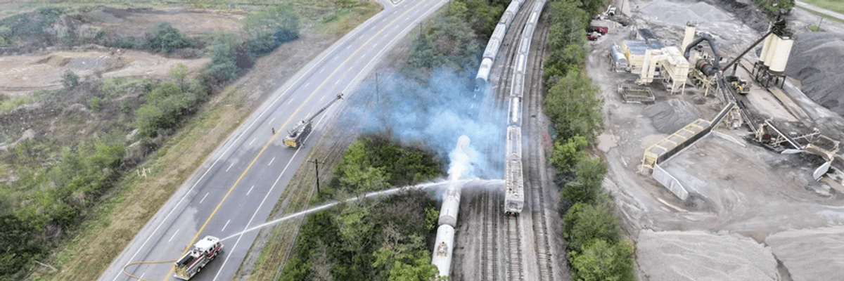 firetrucks spray down a railcar that had leaked a toxic chemical