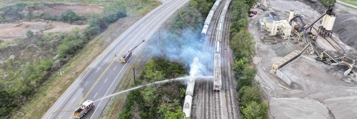 firetrucks spray down a railcar that had leaked a toxic chemical
