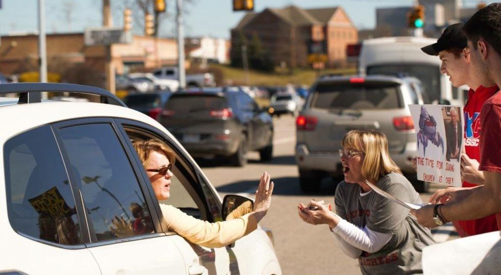 First grade teacher Tammy Klemkowsky receiving chocolate thrown out of car windows from retired teachers. (Photo: Dan Gifford)
