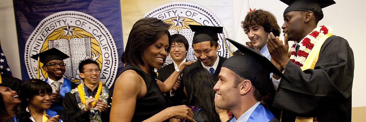 First Lady Michelle Obama meets with students in graduation garb.