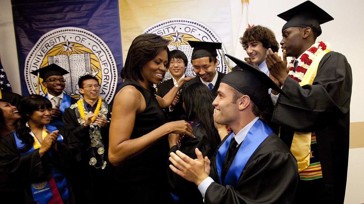 First Lady Michelle Obama meets with students in graduation garb.
