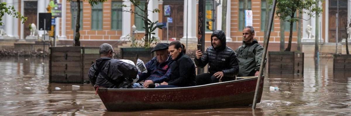 five people in a small boat in a flooded city