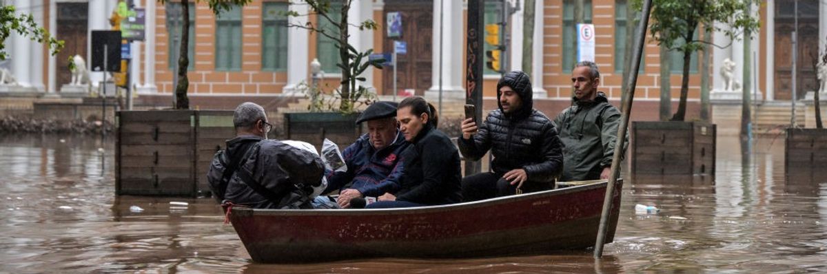 five people in a small boat in a flooded city