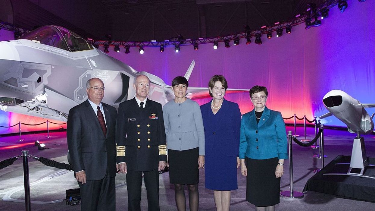 Five people stand in front of an F-35 aircraft.
