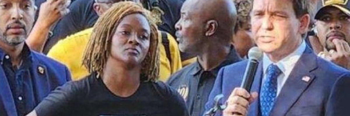 Florida State Rep. Angie Nixon angrily listens to Gov. Ron DeSantis at a vigil for victims of the latest racist shooting.