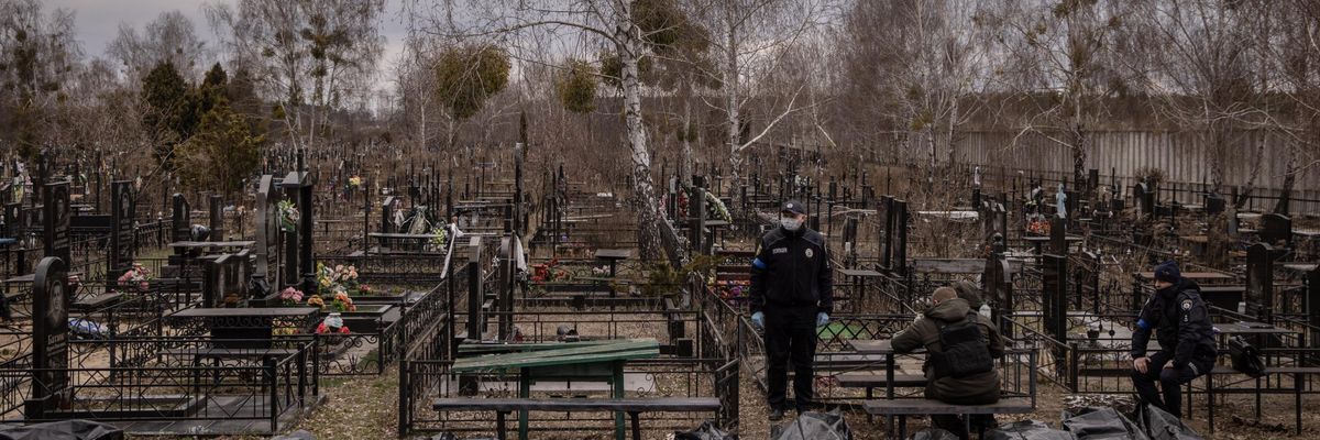 Forensic investigators stand near body bags in Bucha, Ukraine