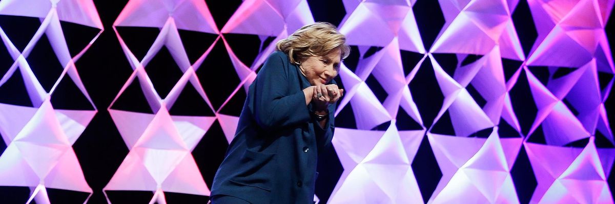 Former Secretary of State Hillary Clinton ducks after a woman threw a shoe toward her