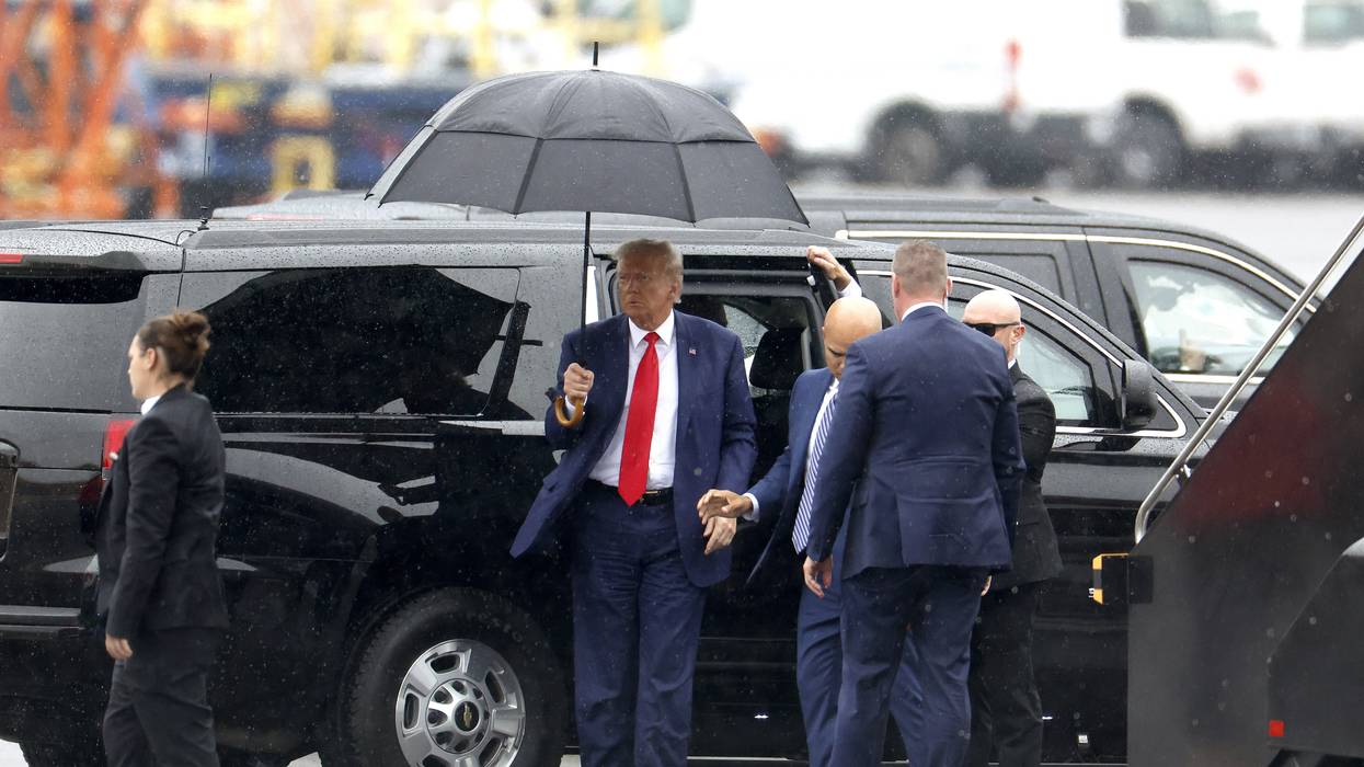 Former U.S. President Donald Trump holds an umbrella