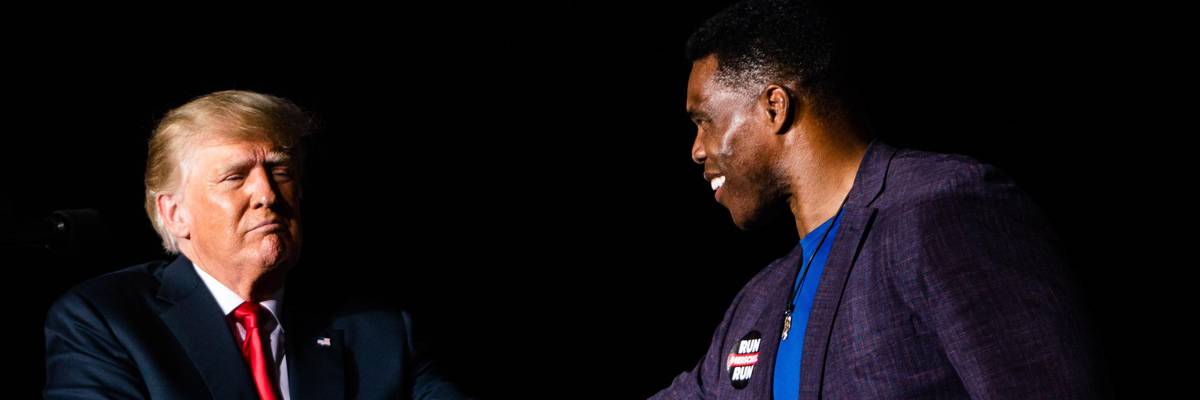 Former U.S. President Donald Trump shakes hands with Republican Senate candidate Herschel Walker at a rally in Perry, Georgia on September 25, 2021.