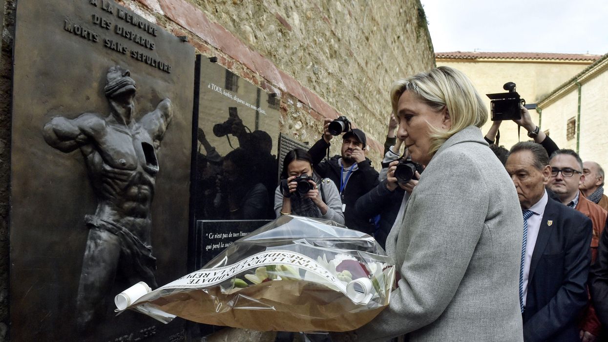 French far-right presidential candidate Marine Le Pen lays flowers at the Wall of the Disappeared, a memorial to colonists in Algeria, during a campaign stop in Perpignan, southern France, on April 8, 2022.