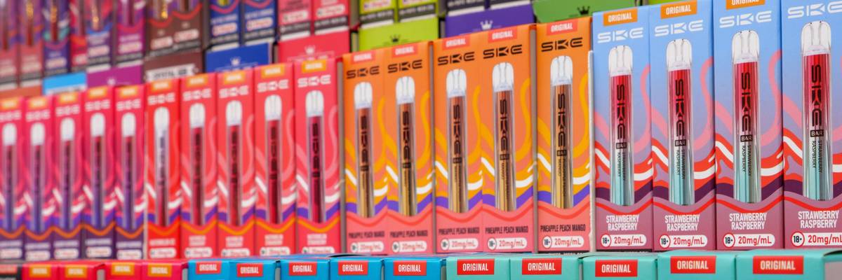 Fruit flavor vape refills for e-cigarettes on shelves of a vaping shop, England, UK