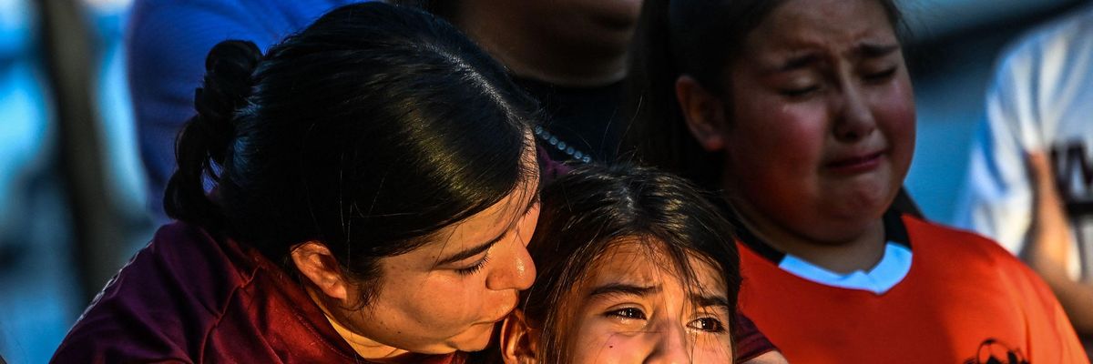 Gabriella Uriegas, a soccer teammate of Tess Mata who died in the massacre at an elementary school in Texas, cries while holding her mother Geneva Uriegas as they visit a makeshift memorial outside the Uvalde County Courthouse on May 26, 2022. 