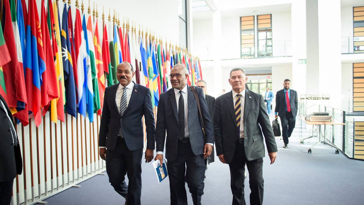 Gaston Browne (L-R), Prime Minister of Antigua and Barbuda; Arnold Loughman, Attorney General of Vanuatu; and Kausea Natano, Prime Minister of Tuvalu, walk down a hallway.