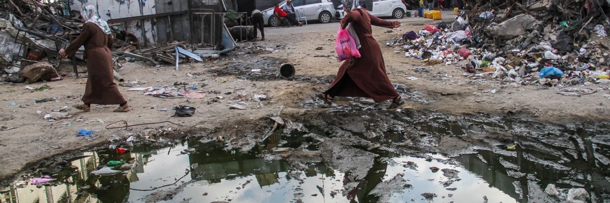Gazans walk among rubble and sewage