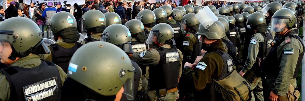 ​Gendarmerie personnel in riot gear stand by demonstrators blocking the Pan-American highway in Buenos Aires on April 10, 2014, during the general strike in Argentina