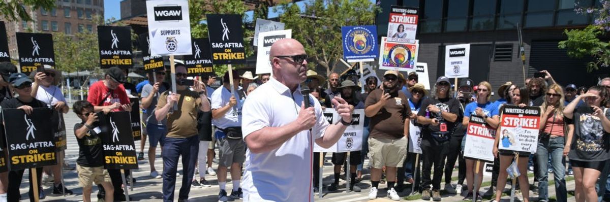 General President of the International Brotherhood of Teamsters Sean O'Brien speaks with striking workers behind him.